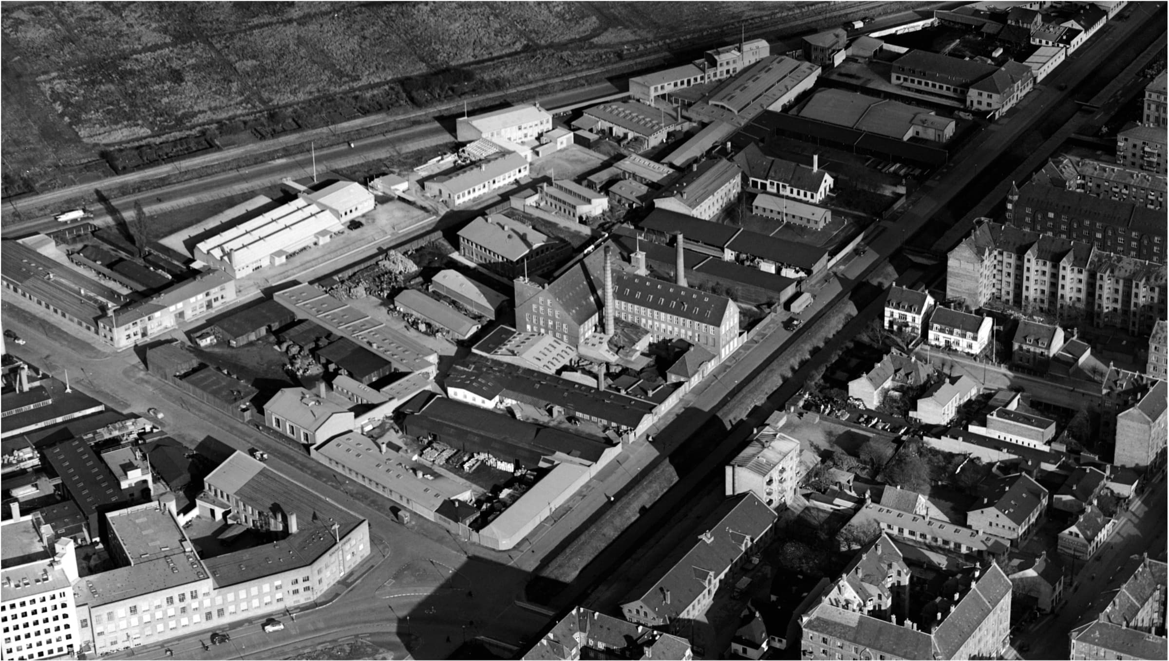 Historisk luftfoto af industrikvarteret ved Prags Boulevard med fabriksbygninger og skorsten